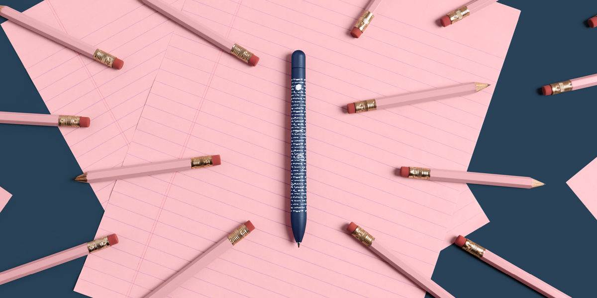 Draft Writing Squire Classic pen on a blue background with pink paper and pink pencils